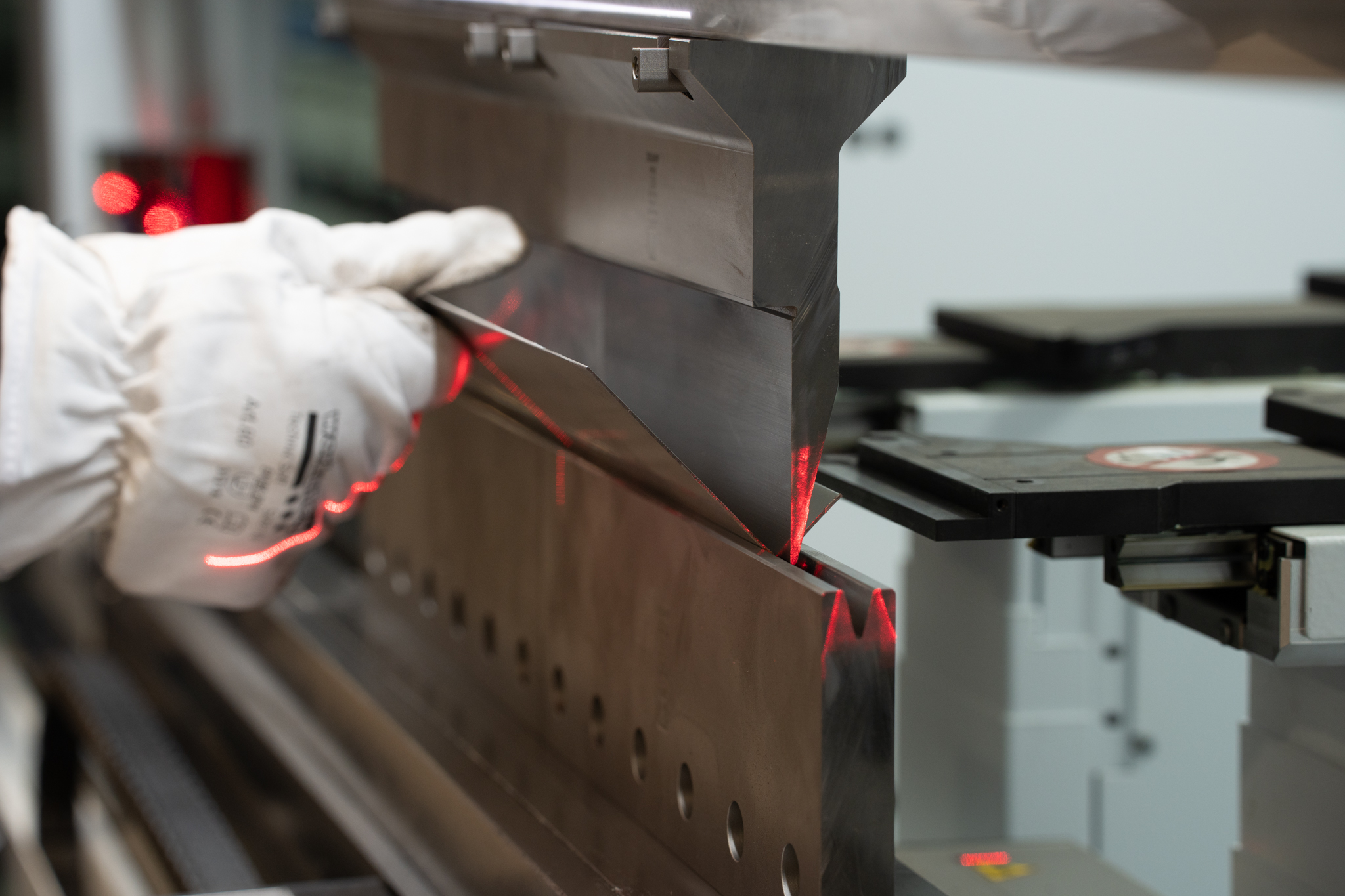 Kantbukning af metalelement af autoriseret CNC Kantbukker, med sikkerhedshandsker og lasermåling